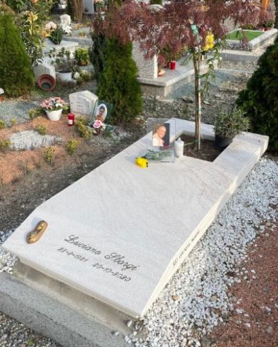 Lapide funeraria in marmo bianco con composizione floreale - Onoranze Funebri Musocco Milano