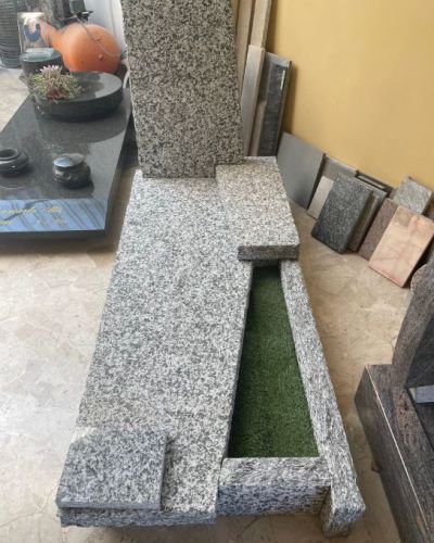 Lapide funeraria in granito grigio dal profilo scalare - Onoranze Funebri Musocco Milano