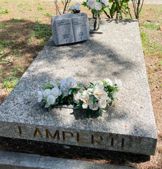 Tomba di famiglia in marmo grigio con composizione floreale - Onoranze Funebri Musocco Milano