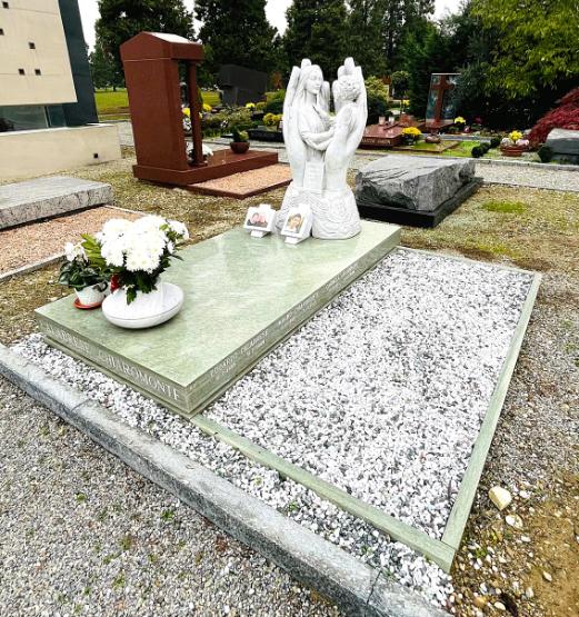 Tomba di famiglia in granito verde con monumento mani che accolgono madre e figlio - Onoranze Funebri Musocco Milano