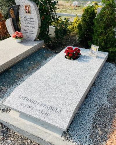 Lapide funeraria in granito rosso dal profilo sagomato - Onoranze Funebri Musocco Milano