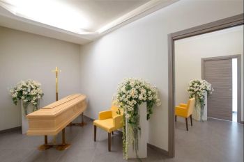 Sala del commiato con feretro, fiori e simbolo religioso - Onoranze Funebri Musocco Milano