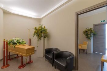 Sala del commiato con feretro e composizioni floreali - Onoranze Funebri Musocco Milano