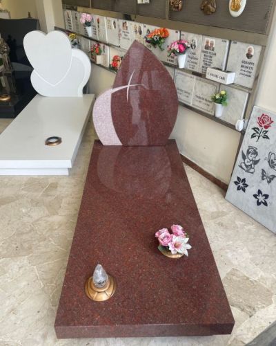 Lapide funeraria in granito rosso dal profilo sagomato - Onoranze Funebri Musocco Milano